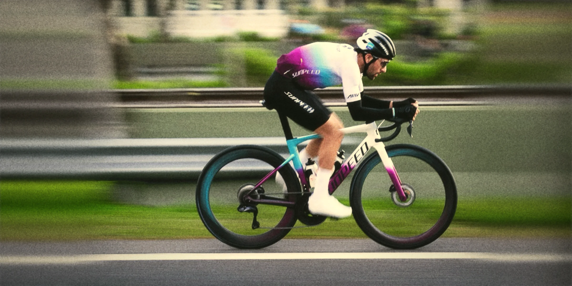Ciclista Sunpeed a fondo sobre el asfalto, con estética de película analógica