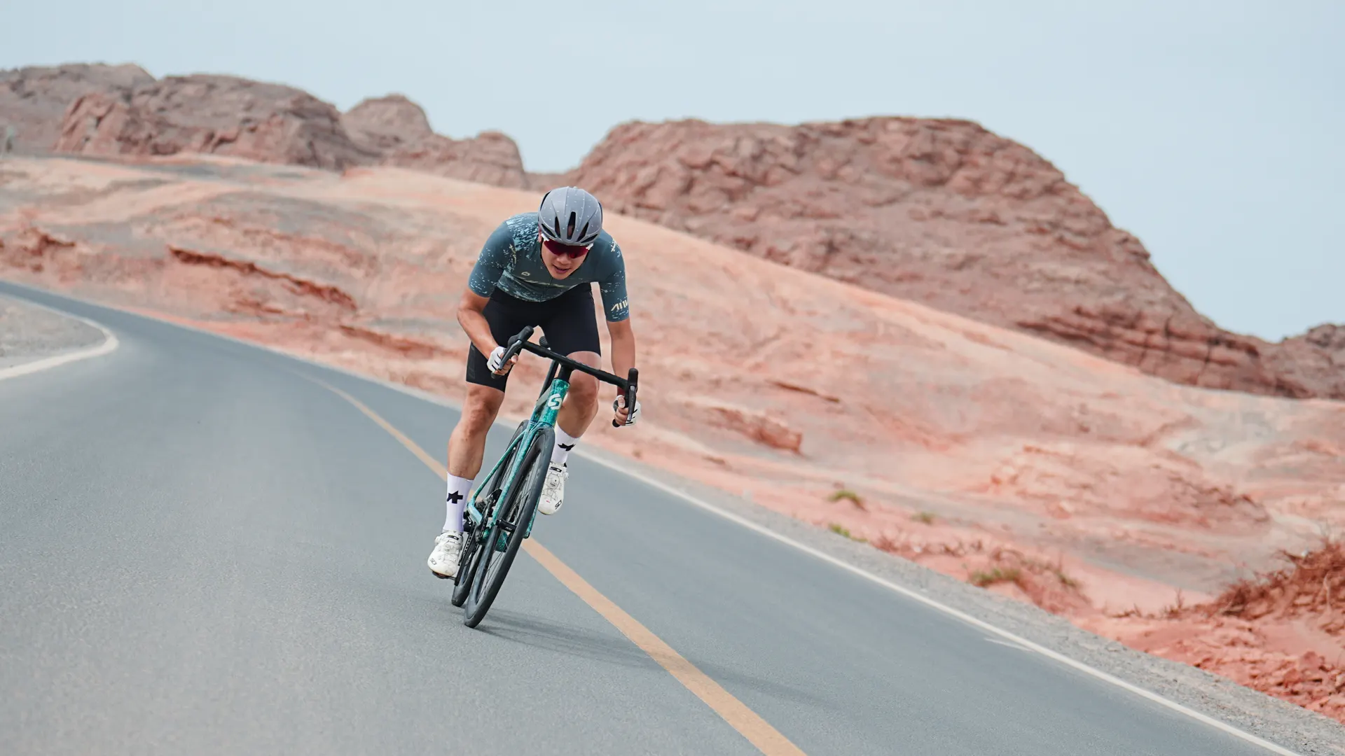 Ciclista Sunpeed en un paso de montaña entre formaciones de roca roja